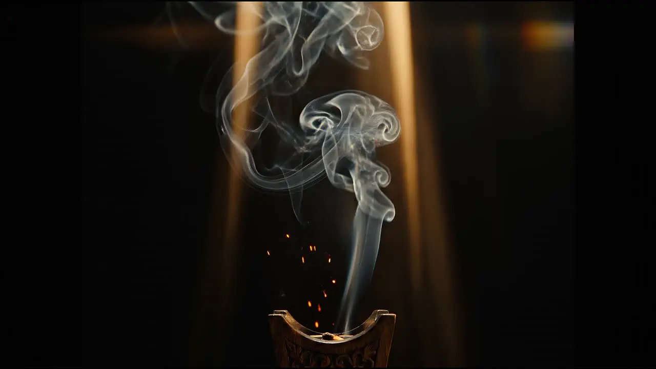 Ribbons of oud smoke rising from a bed of embers, curling into script.